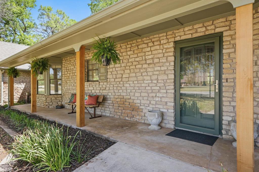 1904 Oak Ridge Trail Bridgeport, TX 76426 - Photo 27 of 34 View of exterior entry featuring stone siding, a porch, and brick siding
