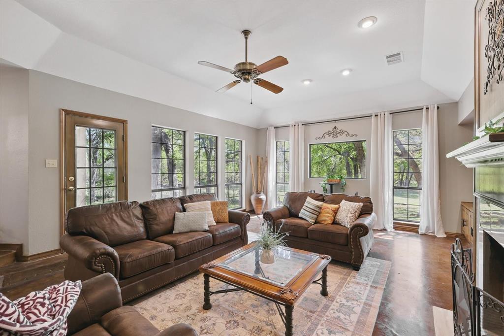 1904 Oak Ridge Trail Bridgeport, TX 76426 - Photo 7 of 34 Living room with ceiling fan, a fireplace with flush hearth, healthy amount of natural light, finished concrete flooring, and recessed lighting