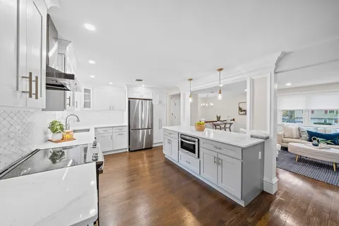 a kitchen with white cabinets and stainless steel appliances