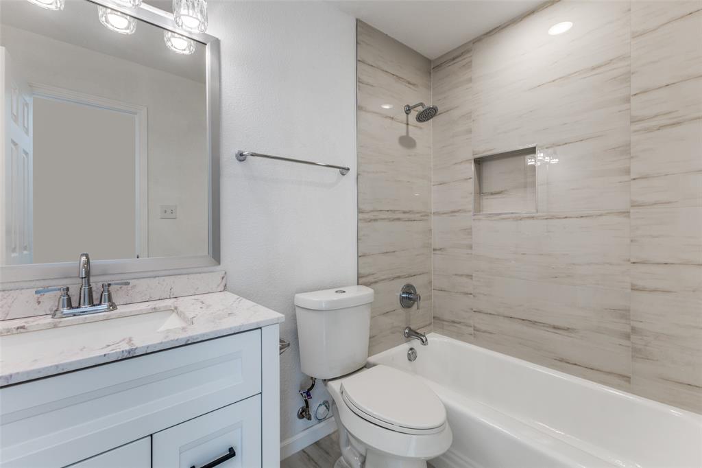 2950 Windmill Lane Farmers Branch, TX 75234 - Photo 21 of 25 a bathroom with a granite countertop toilet a sink and a bathtub