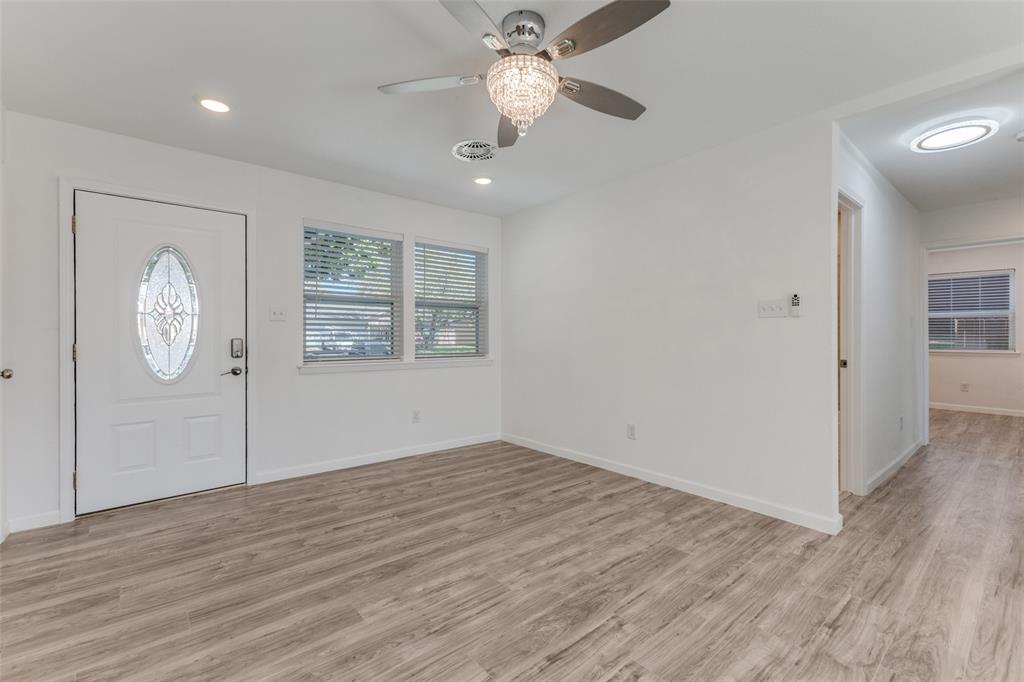 2950 Windmill Lane Farmers Branch, TX 75234 - Photo 5 of 25 an empty room with wooden floor a ceiling fan and windows