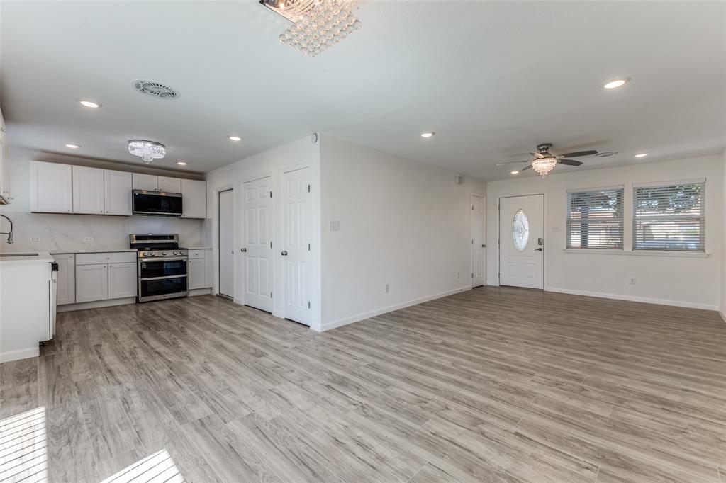 2950 Windmill Lane Farmers Branch, TX 75234 - Photo 8 of 25 an empty room with wooden floor kitchen and windows