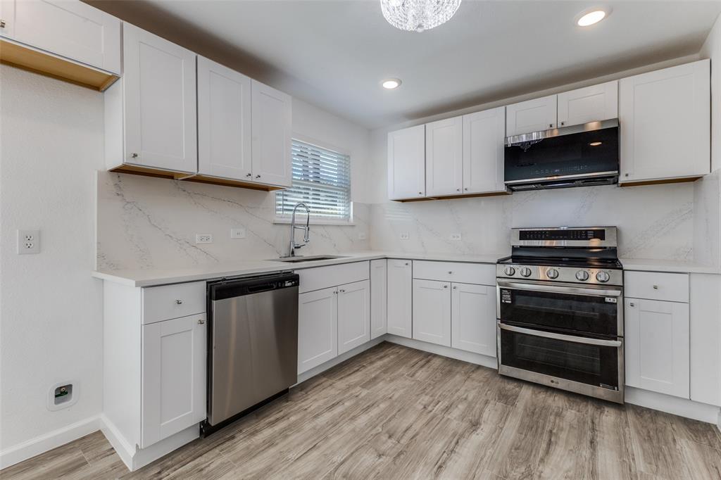2950 Windmill Lane Farmers Branch, TX 75234 - Photo 10 of 25 a kitchen with stainless steel appliances white cabinets and a stove top oven