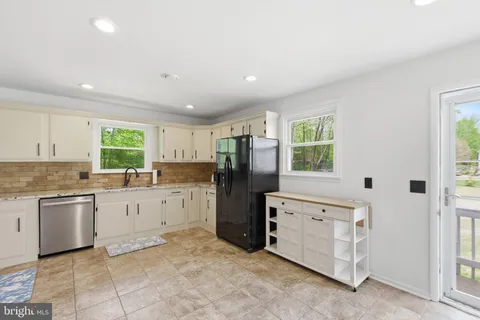 a kitchen with a refrigerator and white cabinets