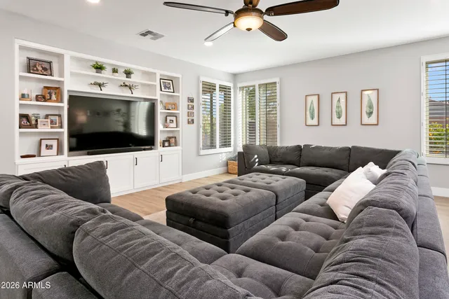 a living room with furniture and a ceiling fan