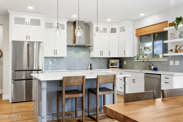 a kitchen with granite countertop white cabinets white appliances and a wide window