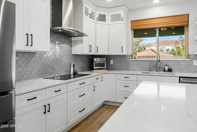a kitchen with granite countertop a sink a stove and cabinets