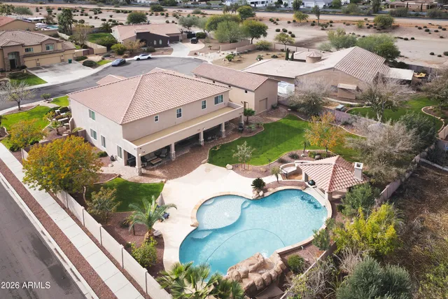 an aerial view of a house with a swimming pool and outdoor seating