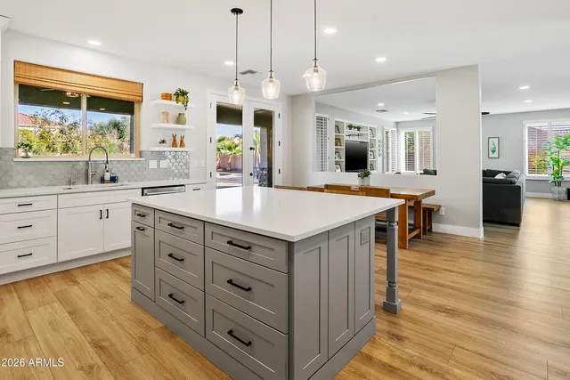 a large kitchen with kitchen island a table and chairs in it