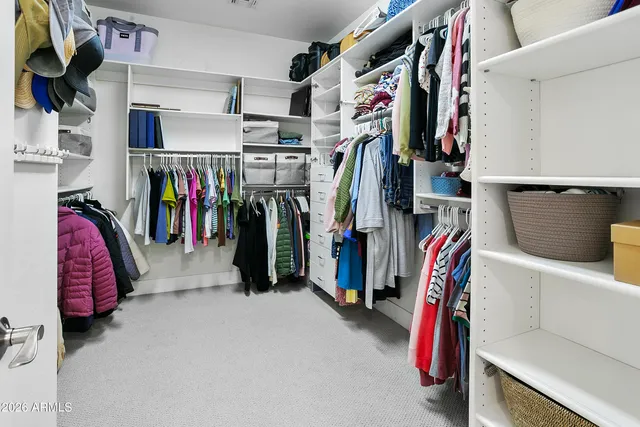 a view of walk in closet with clothes and shoes