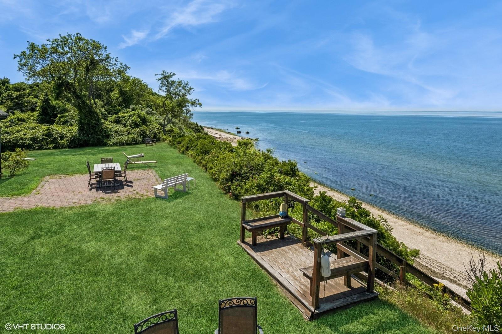 4630 Blue Horizon Bluffs Peconic, NY 11958 - Photo 3 of 13 a wooden bench sitting in the grass near a lake