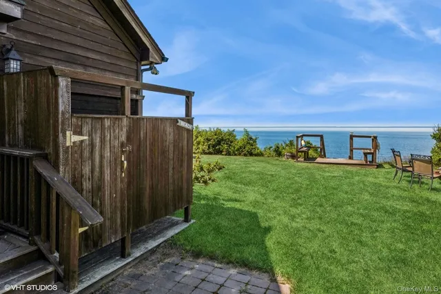 a view of backyard with barbeque grill potted plants and wooden fence