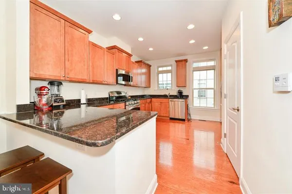 a view of a kitchen with kitchen island a large window cabinets and stainless steel appliances