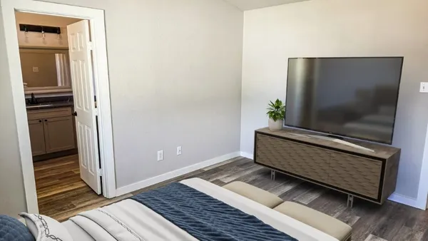 a bedroom with a bed and wooden floor