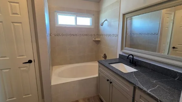 a bathroom with a granite countertop sink toilet and bathtub