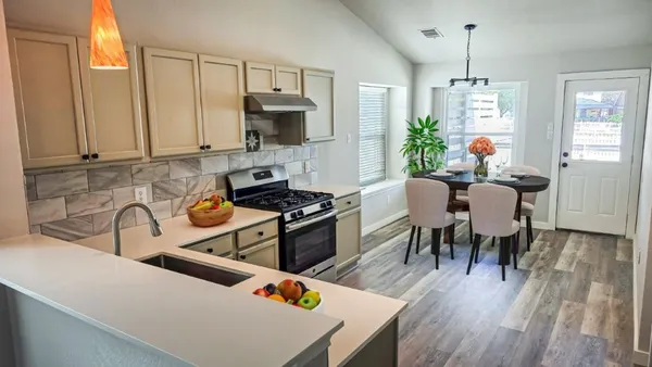 a kitchen with a table chairs stove and cabinets