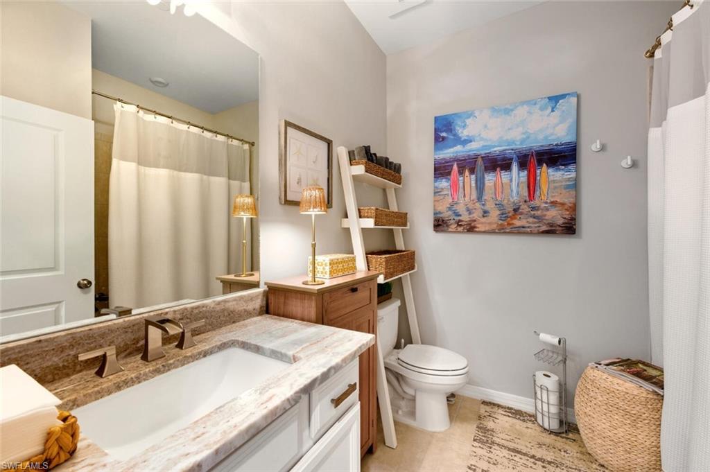9365 Pocida Court, Unit 202 Naples, FL 34119 - Photo 24 of 40 a bathroom with a granite countertop sink toilet and shower