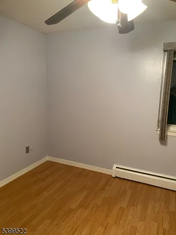 a view of a room with wooden floor and small window