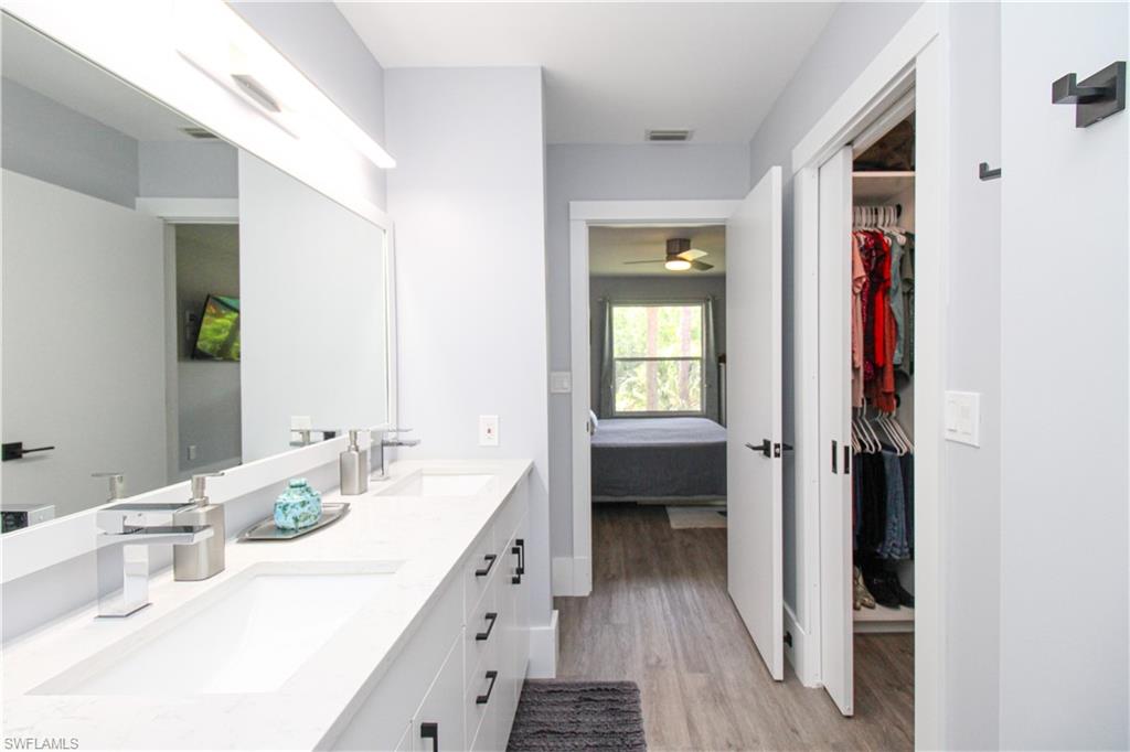225 Robin Hood Circle, Unit 203 Naples, FL 34104 - Photo 41 of 50 Bathroom featuring dual bowl vanity, ceiling fan, and wood-type flooring