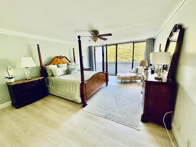 a bedroom with a bed dresser and a large window