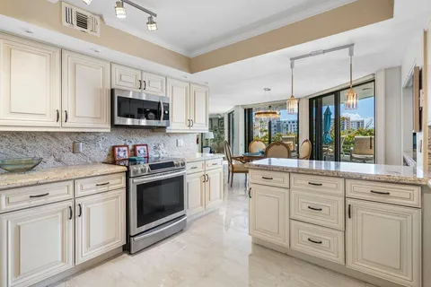 a kitchen with stainless steel appliances granite countertop a sink refrigerator and cabinets