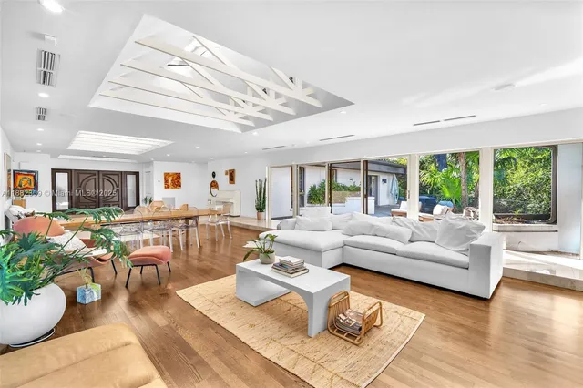 a large white bed sitting in a room next to a window