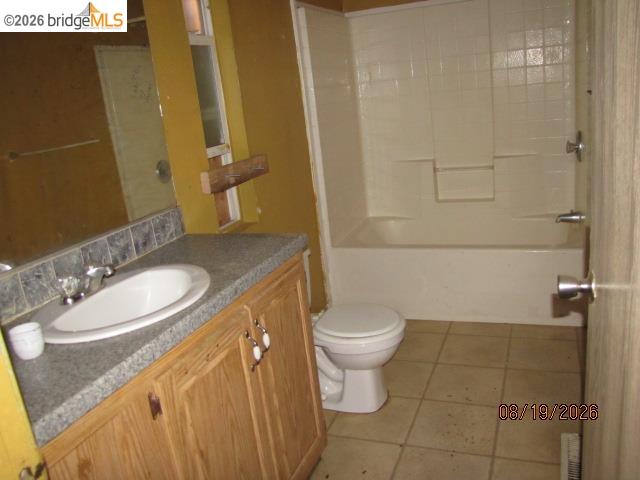 4069 Buckeye Road Mariposa, CA 95338 - Photo 19 of 22 Wood-finish vanity with a drop-in sink and grey countertop, complemented by a white tub and shower surround, and a tiled floor