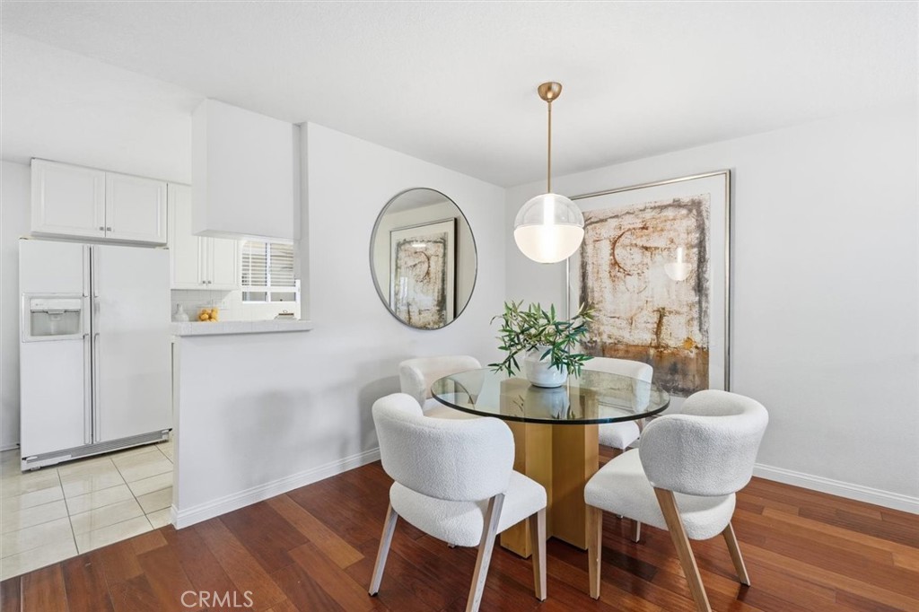 222 7th Street, Unit 202 Santa Monica, CA 90402 - Photo 13 of 41 a dining room with furniture a rug a potted plant and wooden floor