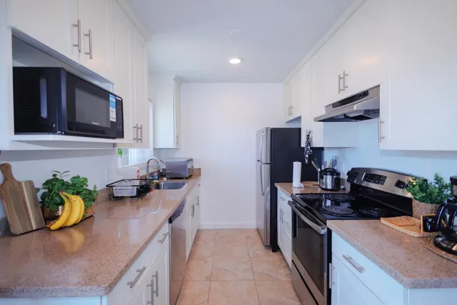 a kitchen with stainless steel appliances granite countertop a sink stove and cabinets