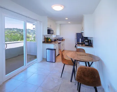 a kitchen with stainless steel appliances a table chairs refrigerator and sink