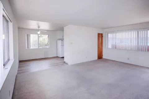 a kitchen with cabinets wooden floor and a window