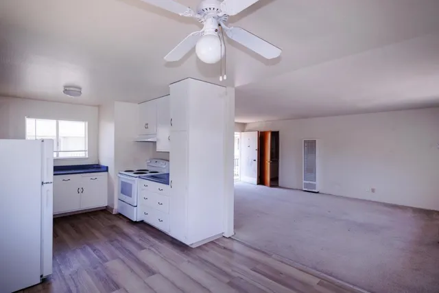 a kitchen with cabinets appliances and wooden floor