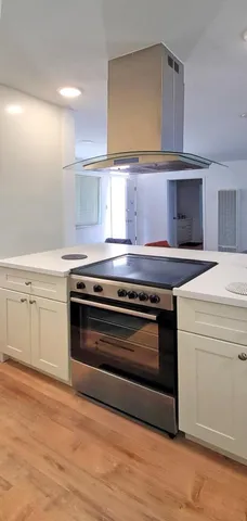 a kitchen with white cabinets and appliances