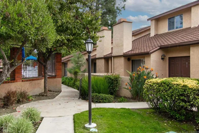 a front view of a house with a garden and plants