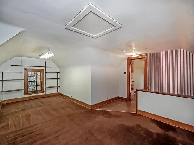 an empty room with windows and fireplace