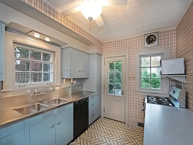 a kitchen with a sink window and cabinets