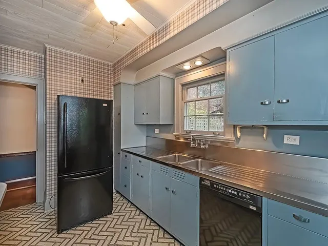 a kitchen with a sink a refrigerator and cabinets