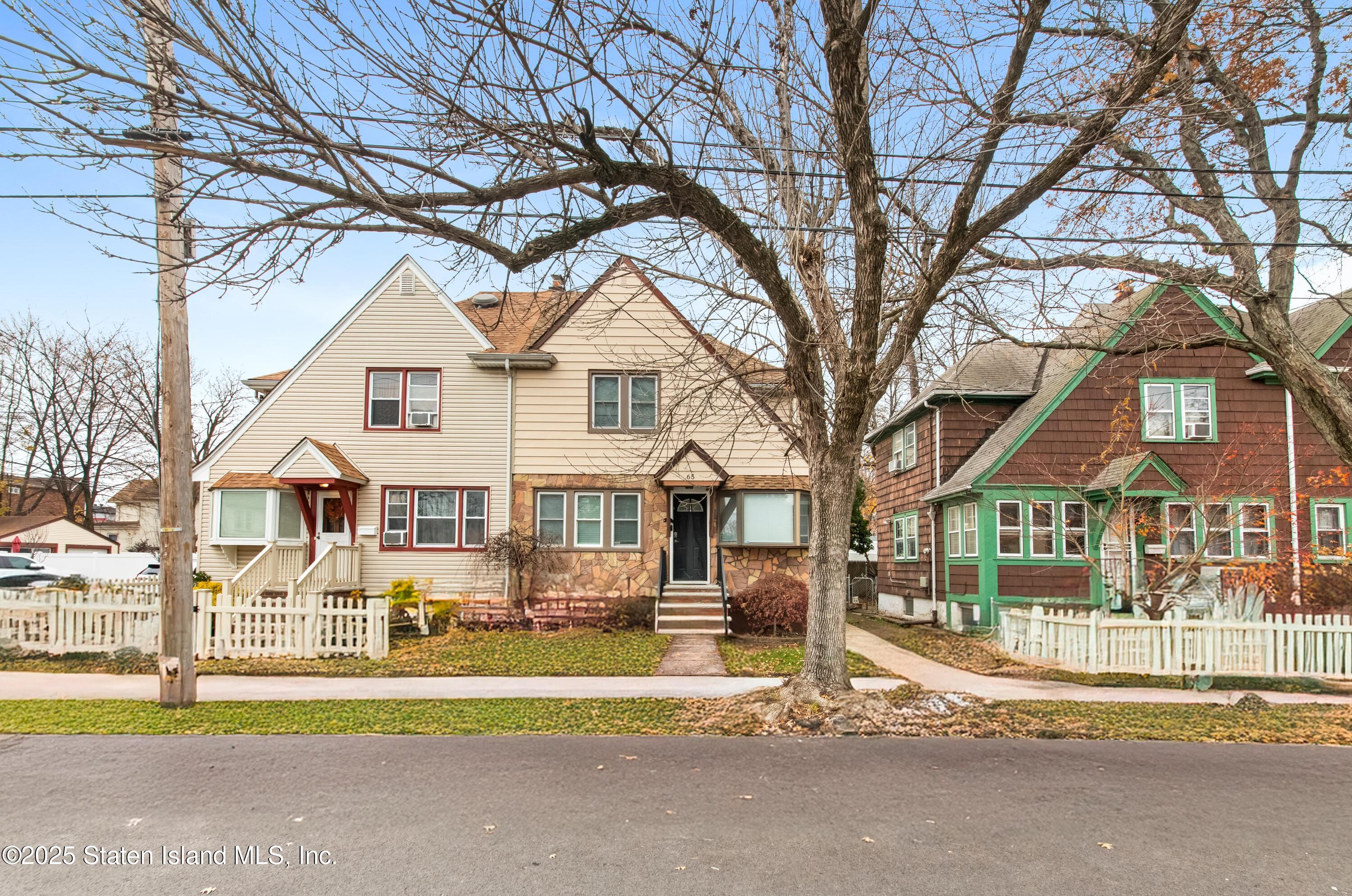 a view of a large trees in front of a brick house