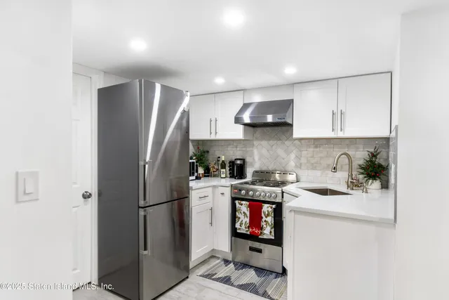 a kitchen with stainless steel appliances granite countertop a refrigerator stove a sink and a microwave