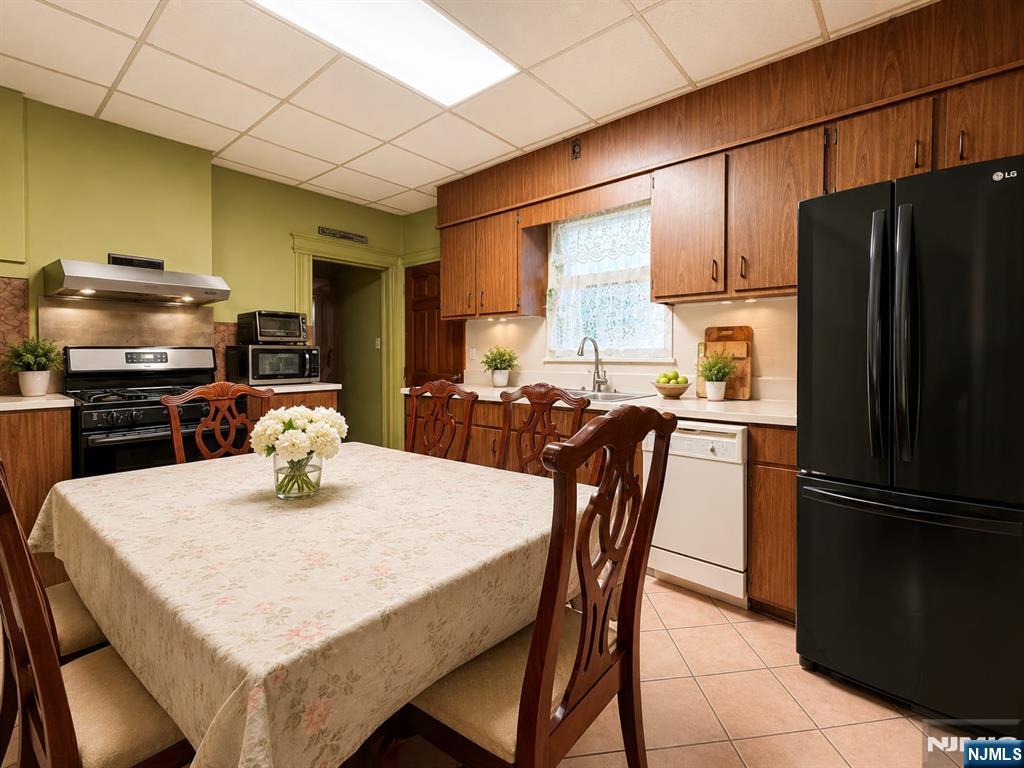 102 State Street Bloomfield, NJ 07003 - Photo 5 of 11 a kitchen with stainless steel appliances granite countertop a refrigerator a stove a sink a dining table and chairs