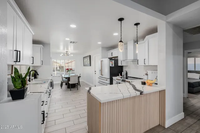 a large white kitchen with a stove top oven and refrigerator