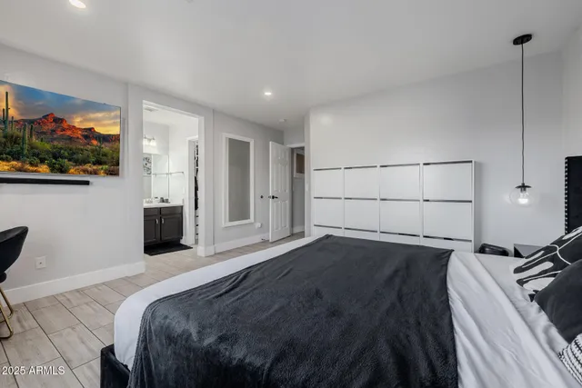 a bedroom with a bed and a painting on the wall