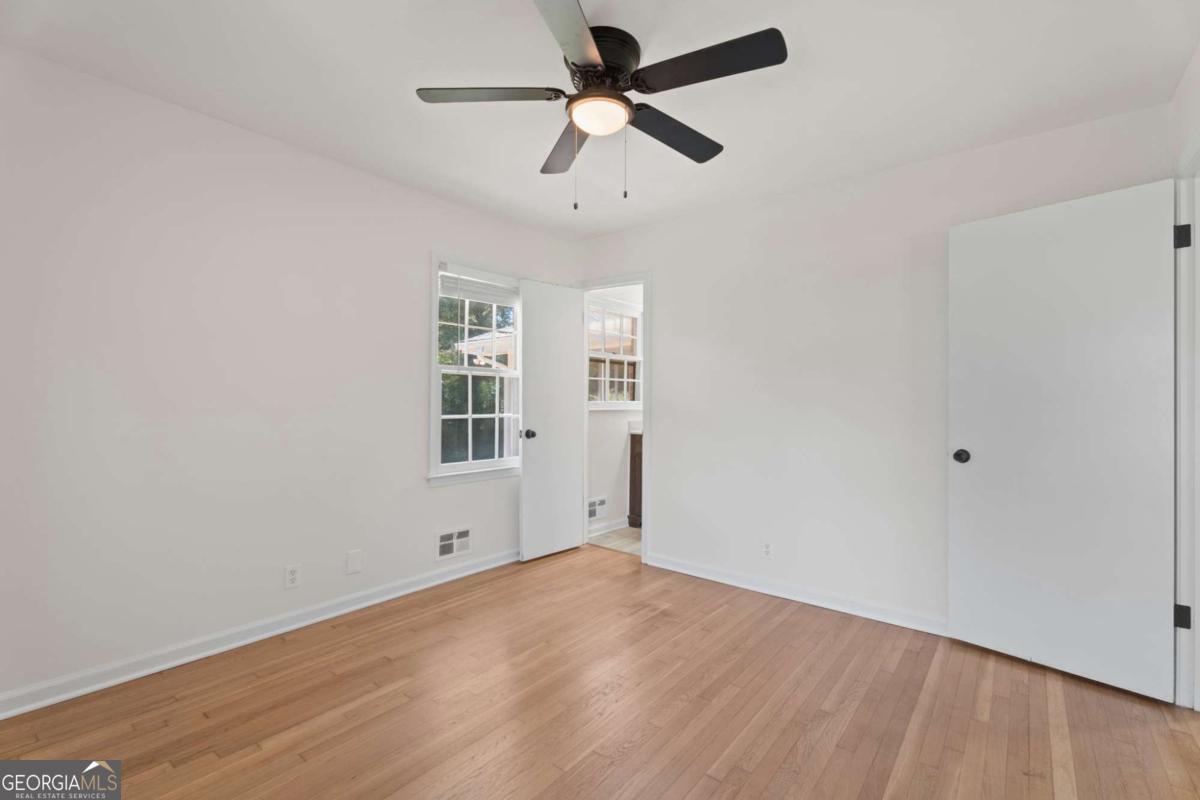 865 Old Tucker Road Stone Mountain, GA 30087 - Photo 29 of 57 an empty room with a window and a ceiling fan