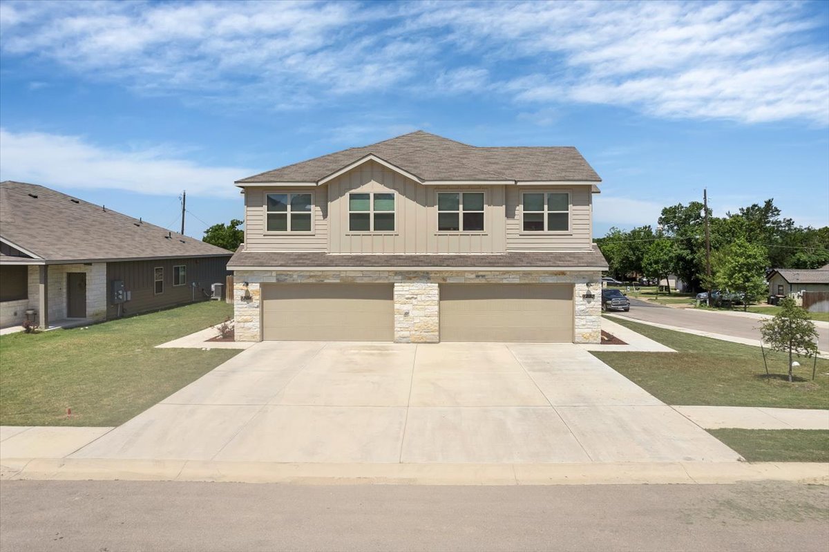 1202 Garland Road Georgetown, TX 78626 - Photo 1 of 28 Two-story property featuring a stone and siding exterior, dual garage doors, and individual concrete driveways