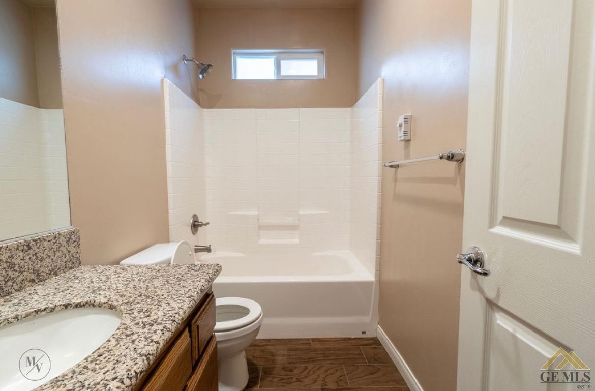 Undisclosed Address Wasco, CA 93280 - Photo 17 of 28 a bathroom with a granite countertop sink a toilet and shower