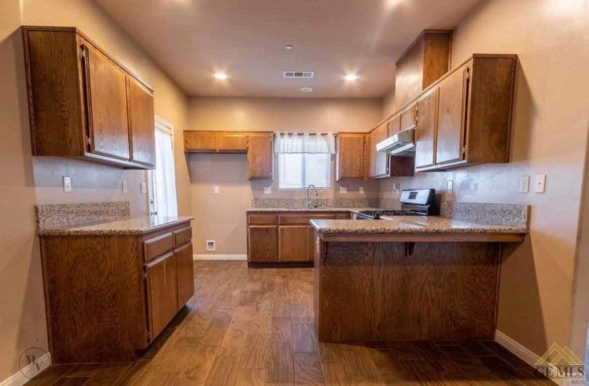 Undisclosed Address Wasco, CA 93280 - Photo 5 of 28 a kitchen with stainless steel appliances granite countertop a stove a sink dishwasher and a refrigerator