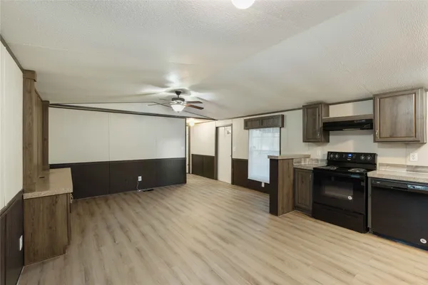 a view of a kitchen with a sink and dishwasher a refrigerator with wooden floor