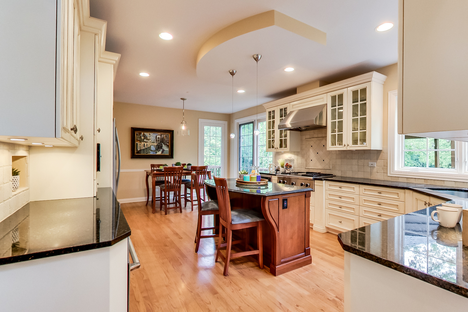 4289 Hilltop Road Long Grove, IL 60047 - Photo 9 of 42 a kitchen with stainless steel appliances granite countertop a stove top oven a sink a dining table and chairs with wooden floor
