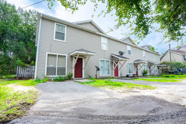 a front view of a house with a yard and trees
