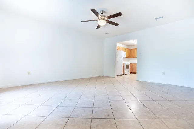 an empty room with a ceiling fan and window